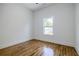 Bedroom with hardwood floors, white trim and walls, and a window with a view of the neighborhood at 115 Dahlia Nw Ave, Atlanta, GA 30314