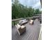 Wooden deck furnished with a sofa, chairs, and a table with a scenic view of the wooded backyard at 124 Gorham Gates Ct, Hiram, GA 30141