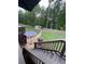 Staircase leading to a wooden deck with a grill, and a backyard with mature trees and a storage shed at 124 Gorham Gates Ct, Hiram, GA 30141