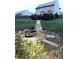 Backyard with a firepit, landscaping, and a dark wood deck with stairs down to a grill and grassy space at 124 Gorham Gates Ct, Hiram, GA 30141