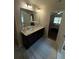 Bright bathroom featuring double sinks, a large mirror, and an open doorway to the bedroom at 124 Gorham Gates Ct, Hiram, GA 30141