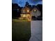 Charming two-story home with a manicured lawn, brick accents, and a welcoming front porch at dusk at 124 Gorham Gates Ct, Hiram, GA 30141