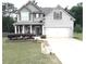 Charming two-story home featuring a landscaped yard, inviting front porch, and a convenient two-car garage at 124 Gorham Gates Ct, Hiram, GA 30141
