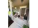 Inviting front porch with rocking chairs, a welcome mat, and decorative plants creating a cozy entrance at 124 Gorham Gates Ct, Hiram, GA 30141