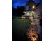 Landscaped front yard with beautiful flower beds and a charming walkway to the front door at dusk at 124 Gorham Gates Ct, Hiram, GA 30141