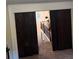 View through dark stained wooden doors of the carpeted hallway and stairwell with white trim at 124 Gorham Gates Ct, Hiram, GA 30141