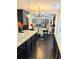 Open kitchen view with granite countertops, modern lighting, stainless appliances, and dark wood flooring at 124 Gorham Gates Ct, Hiram, GA 30141