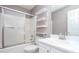 Bright bathroom featuring a shower-tub combo, floating shelves, and modern fixtures at 5414 Sweetsprings Sw Dr, Powder Springs, GA 30127