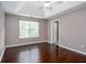 Bedroom with tray ceiling features hardwood floors, a window, and neutral paint at 5414 Sweetsprings Sw Dr, Powder Springs, GA 30127
