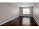 Bedroom with hardwood flooring, a light grey wall paint, a modern light fixture, and a window at 5414 Sweetsprings Sw Dr, Powder Springs, GA 30127