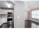 Dining area with dark wood floors, a chandelier, and a view into the kitchen with its stainless-steel appliances at 5414 Sweetsprings Sw Dr, Powder Springs, GA 30127