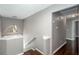 Hallway with brown hardwood floors and a modern light fixture above the stairwell at 5414 Sweetsprings Sw Dr, Powder Springs, GA 30127