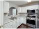 Bright kitchen with white cabinets, stainless-steel appliances, granite countertops, and hardwood floors, perfect for culinary enthusiasts at 5414 Sweetsprings Sw Dr, Powder Springs, GA 30127