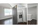Stainless steel refrigerator in a neutral-toned kitchen, with hardwood floors, chandelier lit dining area, and arched entryway at 5414 Sweetsprings Sw Dr, Powder Springs, GA 30127