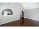 Open-concept living room showcasing hardwood floors and arched entryway to another room at 5414 Sweetsprings Sw Dr, Powder Springs, GA 30127