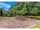 Large stone patio is set in a backyard featuring mature landscaping at 5414 Sweetsprings Sw Dr, Powder Springs, GA 30127