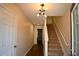 Hallway with hardwood floors, a staircase with white trim and a contemporary light fixture at 920 Society Sw Cir, Atlanta, GA 30331