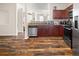 A well-equipped kitchen featuring modern stainless steel appliances, wood cabinets, and attractive wood flooring at 920 Society Sw Cir, Atlanta, GA 30331