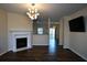 Spacious living room with a fireplace, modern light fixture and hardwood floors at 920 Society Sw Cir, Atlanta, GA 30331