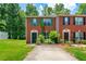 Charming brick townhouse featuring a well-manicured front lawn and colorful, contrasting shutters at 1382 Hollenbeck Ln, Riverdale, GA 30296