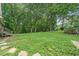 Sprawling backyard with lush greenery, mature trees, and natural stone pavers at 1580 Lower Burris Rd, Canton, GA 30114