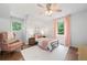 Cozy bedroom featuring hardwood floors, a ceiling fan, and bright natural light from the surrounding landscape at 1580 Lower Burris Rd, Canton, GA 30114