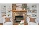 Cozy living room featuring a stone fireplace with built-in shelving, and white armchairs at 1580 Lower Burris Rd, Canton, GA 30114