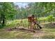 Wooden playground featuring swings, a slide, and a climbing structure in a grassy yard at 1580 Lower Burris Rd, Canton, GA 30114