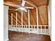 Spacious attic area with wood flooring, a beamed ceiling with fan, white railing and natural light from windows at 5642 Dorsett Shoals Rd, Douglasville, GA 30135
