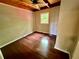 Bright bedroom with hardwood floors, natural lighting through a window, and wood ceiling beams offers a warm retreat at 5642 Dorsett Shoals Rd, Douglasville, GA 30135