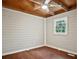 Cozy bedroom with wood-paneled walls, wood-beamed ceiling, a ceiling fan, and a window with natural light at 5642 Dorsett Shoals Rd, Douglasville, GA 30135