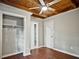 Cozy bedroom with wood floors, wood paneled ceiling with fan, closet and entryways, providing ample storage at 5642 Dorsett Shoals Rd, Douglasville, GA 30135