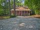 Log cabin with a quaint front porch nestled among mature trees at 5642 Dorsett Shoals Rd, Douglasville, GA 30135