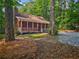 Charming log cabin with a stone chimney and inviting front porch at 5642 Dorsett Shoals Rd, Douglasville, GA 30135