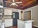 Bright kitchen with white cabinetry, granite countertops, and a unique wood paneled ceiling with a ceiling fan at 5642 Dorsett Shoals Rd, Douglasville, GA 30135