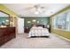 This large bedroom offers plenty of natural light, a ceiling fan, and neutral carpet flooring throughout at 1655 Peachcrest Dr, Lawrenceville, GA 30043