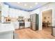 Well-lit kitchen features stainless steel appliances, white cabinetry and hardwood floors at 1655 Peachcrest Dr, Lawrenceville, GA 30043