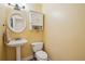 Compact powder room with a pedestal sink, toilet, and a decorative mirror, perfect for guests at 5686 Grindstone Dr, Buford, GA 30518