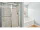 Bathroom showcasing a shower with a glass door and a soaking tub at 5686 Grindstone Dr, Buford, GA 30518