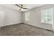 Spacious bedroom with neutral carpet, ceiling fan, and bright natural light from two windows at 732 Jamestown Xing, Jonesboro, GA 30238