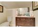 Bathroom featuring a vanity with drawers, a white toilet, and a mirror, creating a functional space at 805 Cog Hl, Mcdonough, GA 30253