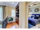 Bright bedroom featuring hardwood floors, built-in bookshelf, and a view into a beautifully decorated bedroom with blue accents at 805 Cog Hl, Mcdonough, GA 30253
