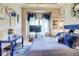 Stylish bedroom featuring a blue-themed decor with a decorative mirror and a desk under a window with white curtains at 805 Cog Hl, Mcdonough, GA 30253