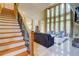 Bright living room featuring high ceilings, floor-to-ceiling windows, tile flooring, a staircase, and contemporary furniture at 805 Cog Hl, Mcdonough, GA 30253