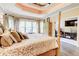 Bright main bedroom features a four-poster bed, tray ceiling, hardwood floors, and views into an office space at 805 Cog Hl, Mcdonough, GA 30253