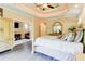 Elegant main bedroom featuring a four-poster bed, tray ceiling, hardwood floors, and glimpses into other rooms at 805 Cog Hl, Mcdonough, GA 30253