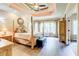 Spacious main bedroom features a four-poster bed, tray ceiling, hardwood floors, and an abundance of natural light at 805 Cog Hl, Mcdonough, GA 30253