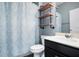 Modern bathroom showcases a sleek vanity, open shelving, and stylish shower curtain at 132 Berkleigh Trails Dr, Hiram, GA 30141