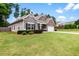 Inviting single-story home with lush green lawn, stone accents, and attached two-car garage at 132 Berkleigh Trails Dr, Hiram, GA 30141