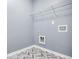 Dedicated laundry room with herringbone tile floor, utility sink hookup, and upper shelving at 132 Berkleigh Trails Dr, Hiram, GA 30141